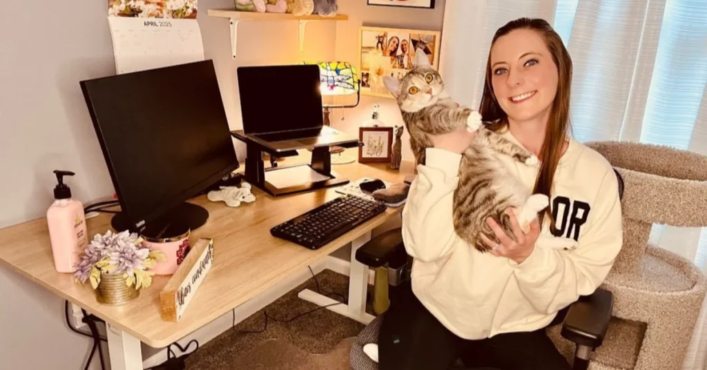 Girl sitting at desk holding kitten