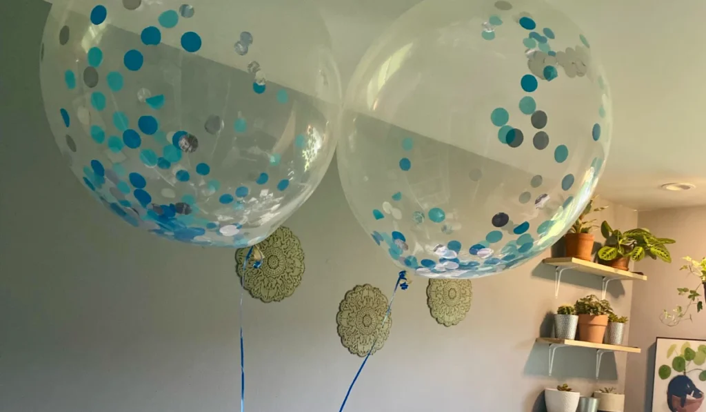 Clear balloons with blue confetti inside with blue ribbon that could cause vomiting and other health issues if a cat eats it